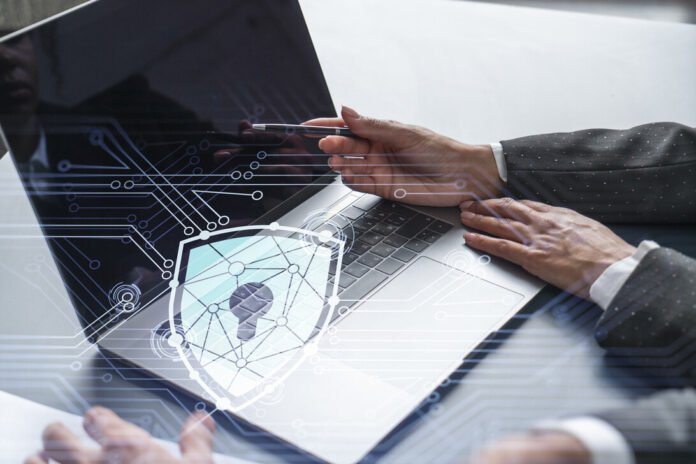 Two business people working on the project to protect cyber security of international company using laptop. Padlock Hologram icons. Teamwork concept.